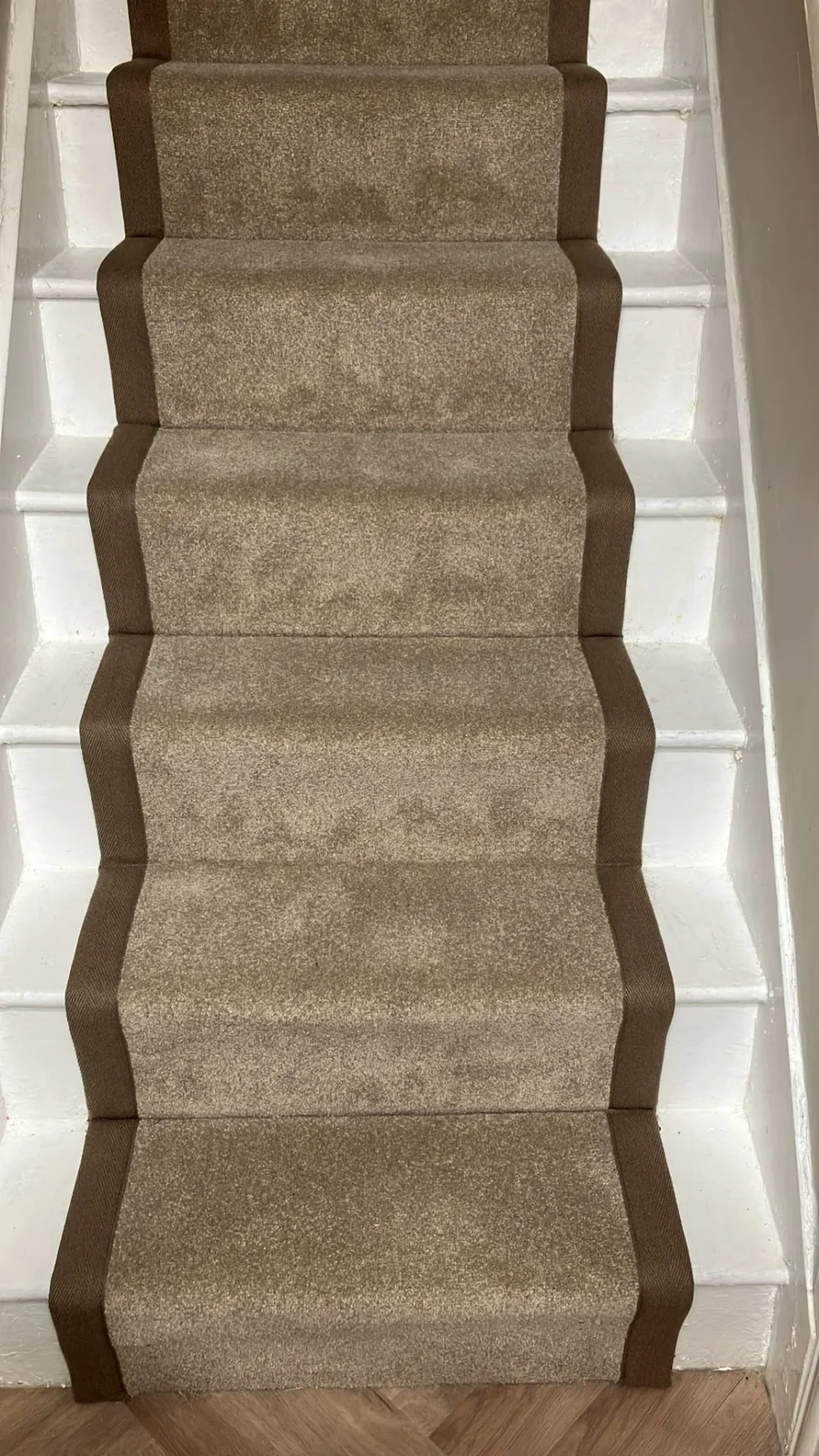 Neutral stair runner finished with wide dark tape binding
