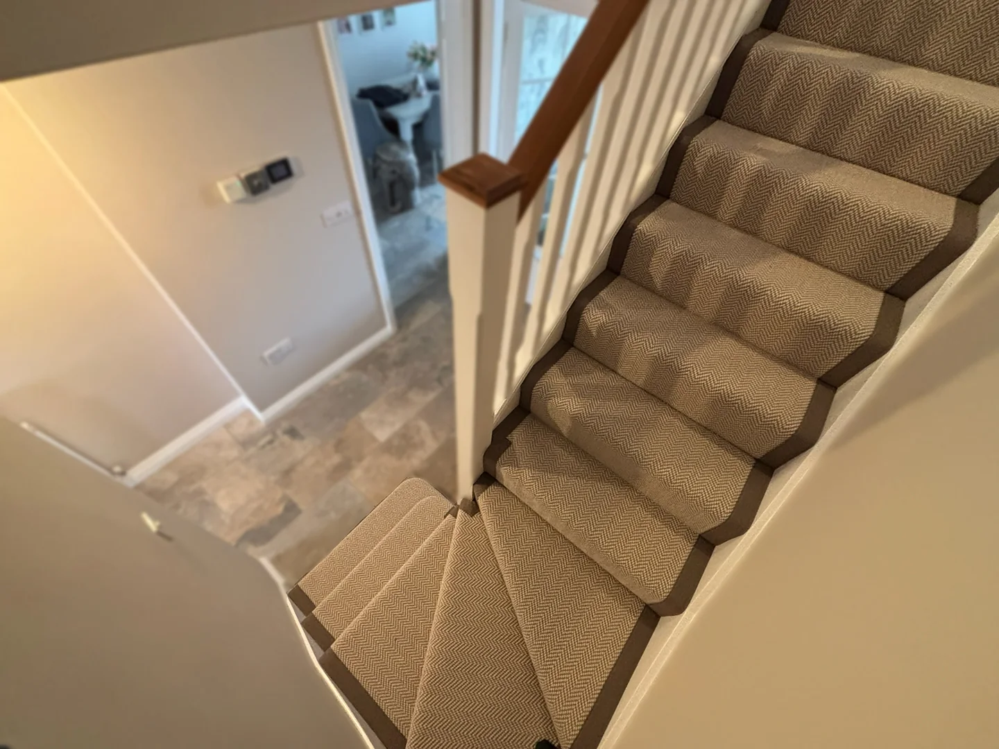 Herringbone stair runner with dark tape binding viewed from the landing